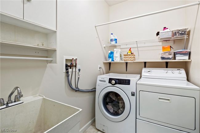 Clothes washing area featuring washing machine and clothes dryer and sink | Image 11