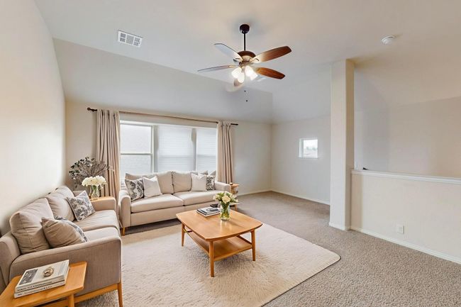 Living area with a ceiling fan, light carpet, lofted ceiling, and baseboards | Image 13