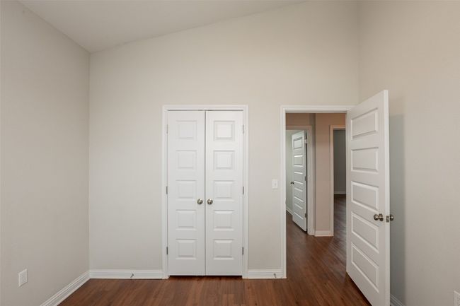 Unfurnished bedroom with baseboards, a closet, and dark wood finished floors | Image 29