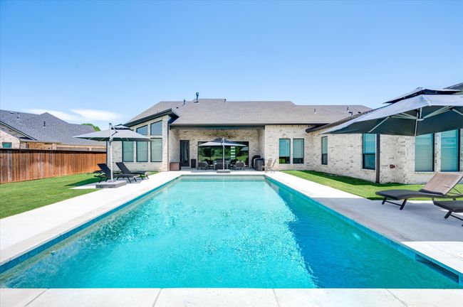 View of swimming pool with a patio, a yard, fence, and a fenced in pool | Image 33