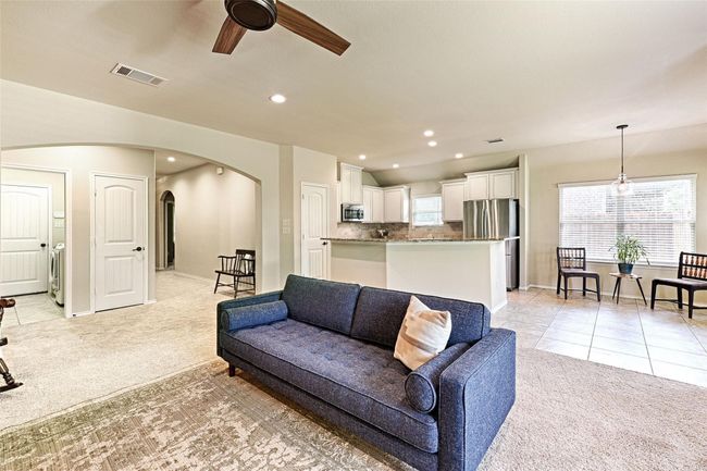 Living area featuring light carpet, arched walkways, a ceiling fan, recessed lighting, and healthy amount of natural light | Image 8