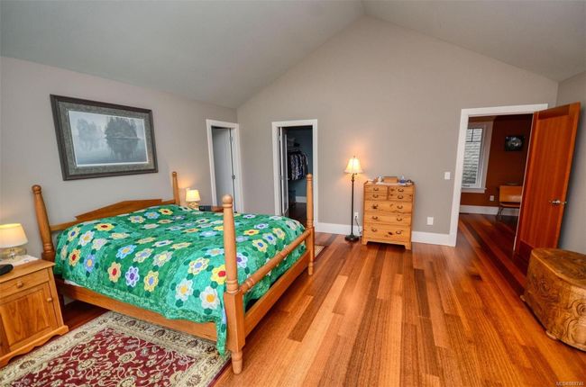 Primary Bedroom with lofted ceiling, a spacious closet, hardwood flooring | Image 14