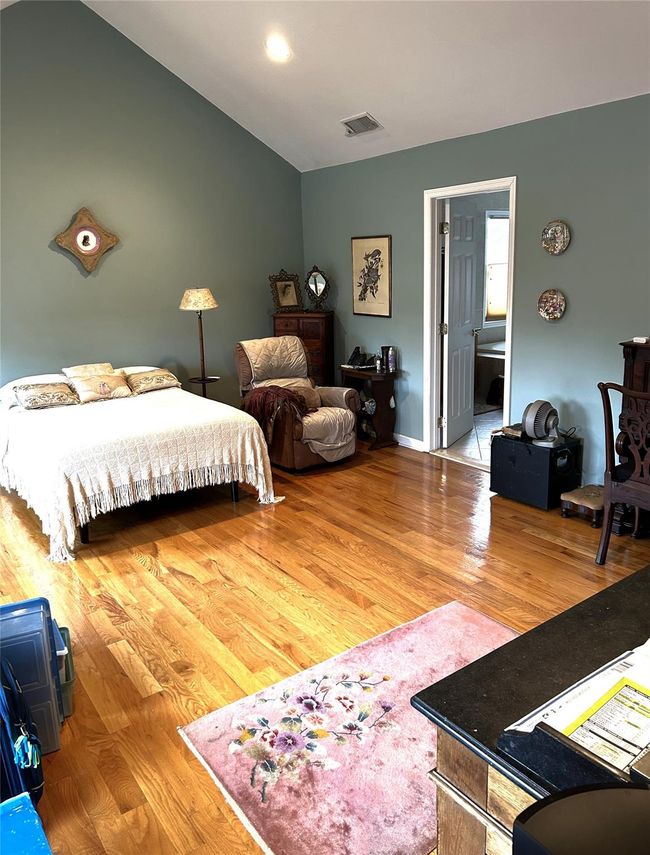 Bedroom with wood finished floors and vaulted ceiling | Image 25