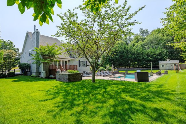 View of yard with a wooden deck, an outdoor pool, a shed, and a patio | Image 41
