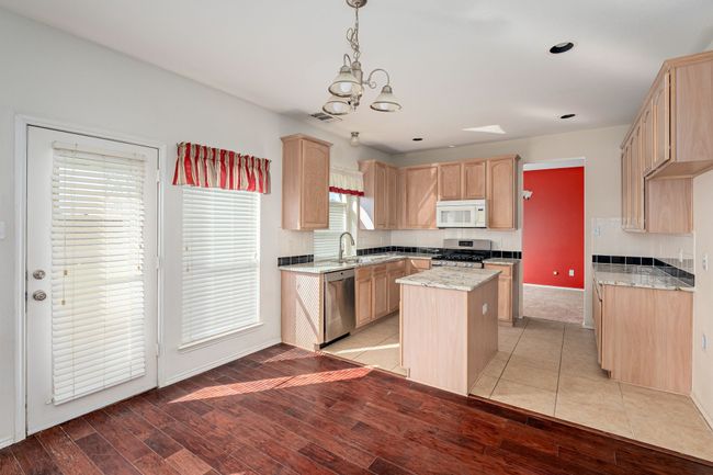 Kitchen featuring stainless steel appliances, light brown cabinets, a kitchen island, a chandelier, and recessed lighting | Image 8