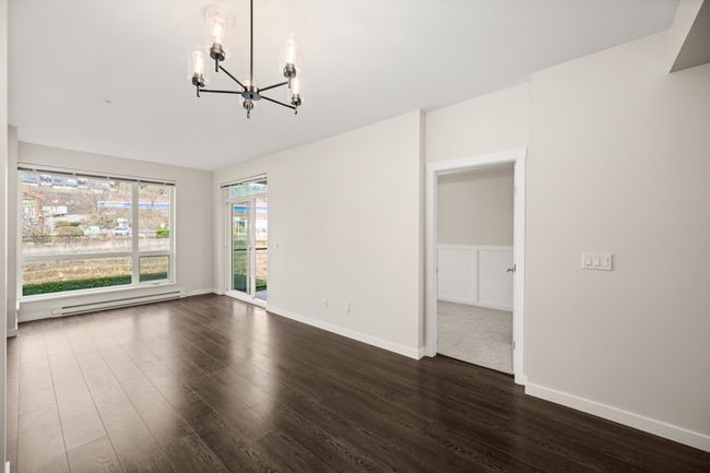 Unfurnished room with a chandelier, dark wood-type flooring, and a baseboard radiator | Image 7