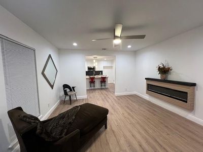 Sitting room with light hardwood / wood-style flooring and ceiling fan | Image 2