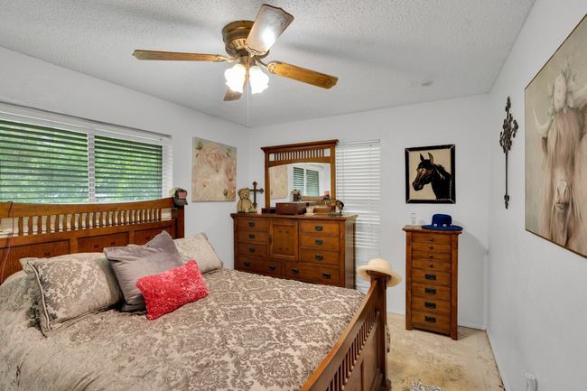 Bedroom featuring a ceiling fan and a textured ceiling | Image 11