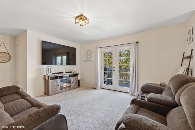 Carpeted living area featuring baseboards and a glass covered fireplace | Image 13
