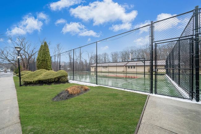 View of sport court featuring a gate, fence, and a yard | Image 5
