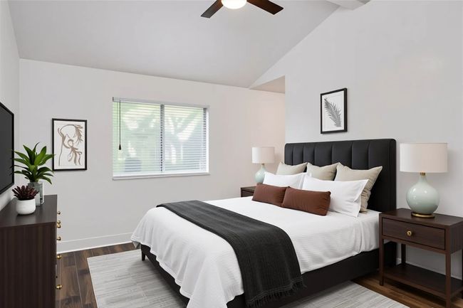 Bedroom with wood finished floors, baseboards, ceiling fan, and high vaulted ceiling | Image 22