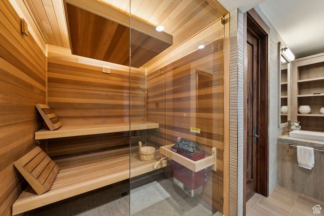 Sauna with wooden walls, wooden ceiling, and tile patterned floors | Image 80