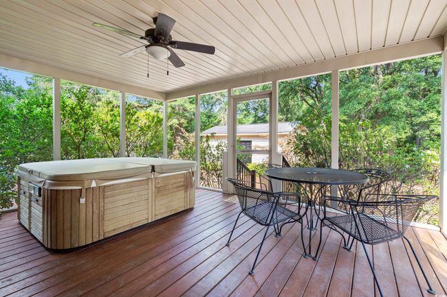 Sunroom / solarium featuring a jacuzzi, outdoor dining area, and ceiling fan | Image 23