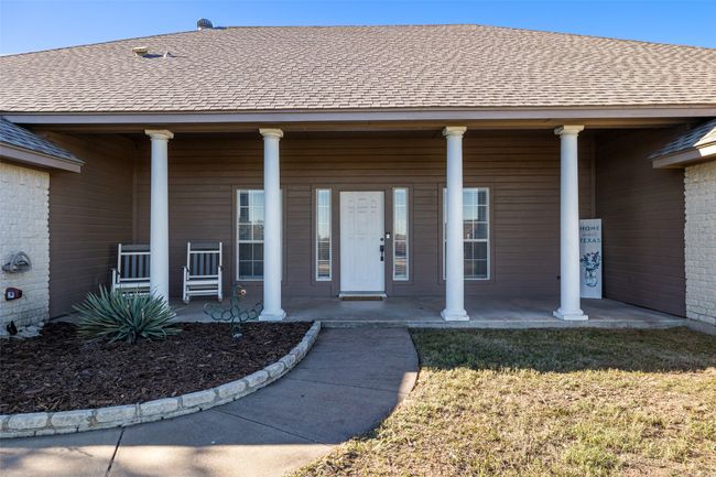 Entrance to property with roof with shingles, a porch, and a lawn | Image 7