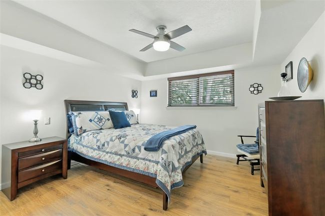 The third bedroom has vinyl plank floors (2016), tray ceilings, an updated ceiling fan and an en-suite bathroom. | Image 24