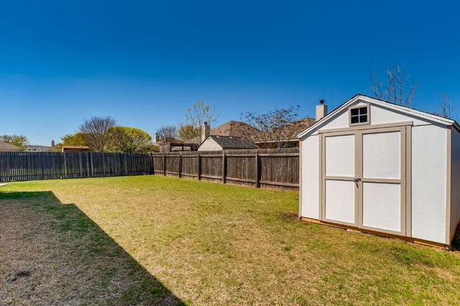 Fenced backyard with a storage unit | Image 27