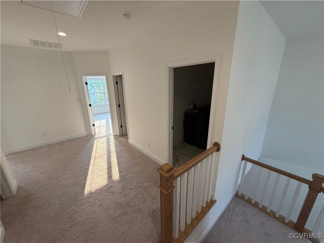 Corridor with attic access, an upstairs landing, carpet flooring, and baseboards | Image 5