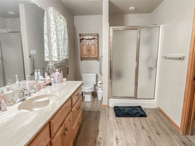 Full bath featuring toilet, wood finished floors, vanity, and a stall shower | Image 16
