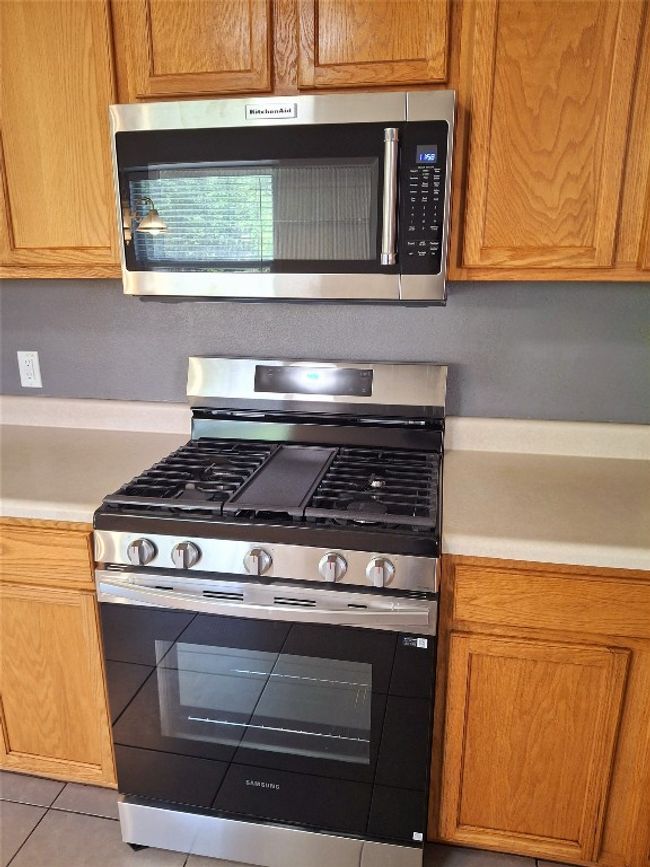 Kitchen featuring stainless steel appliances and light countertops | Image 16