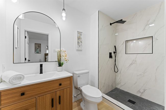 Full bath with vanity, a marble finish shower, and wood finished floors | Image 14