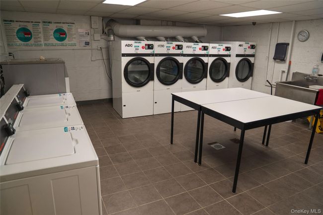 Shared laundry room with separate washer and dryer and dark tile patterned flooring | Image 11