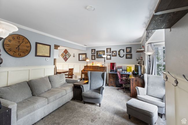 Living room featuring carpet, ornamental molding, an office area, and a wainscoted wall | Image 4