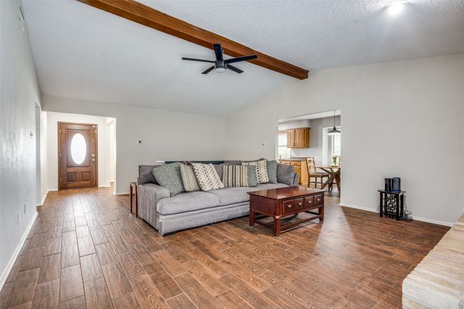 Living area with wood finished floors, ceiling fan, and a textured ceiling | Image 4