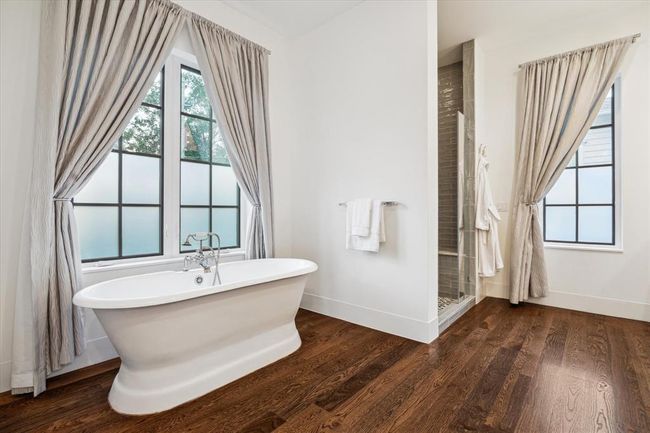 PRIMARY BATHROOM. Features double vanities, large walk in shower and stand alone tub. Marble countertops, sconce lighting and custom mirrors. Imagine drawing the drapes on a winter night and relaxing in the tub. Pure luxury! | Image 17