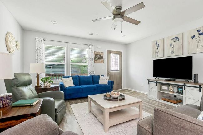Living area with visible vents, light wood finished floors, baseboards, and ceiling fan | Image 5
