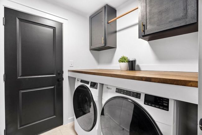The custom-designed laundry room offers extra cabinet storage and counter space to make laundry day a breeze. | Image 30
