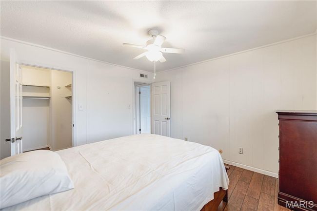 Bedroom with wood-type flooring, ceiling fan, and ornamental molding | Image 41