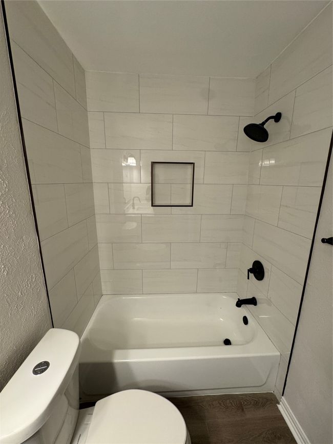 Full bathroom featuring toilet, wood finished floors, and shower combination | Image 14