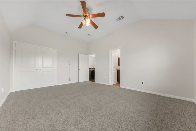 Unfurnished bedroom featuring vaulted ceiling, a closet, carpet floors, baseboards, and ceiling fan | Image 10