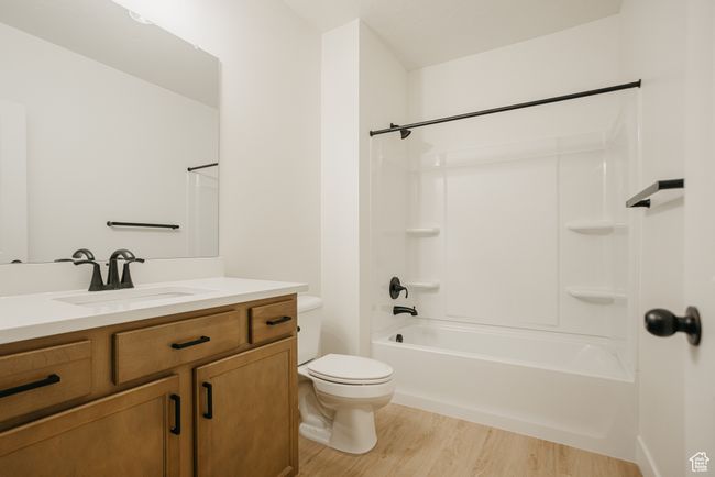 Full bathroom with toilet, hardwood / wood-style flooring, vanity, and bathtub / shower combination | Image 31