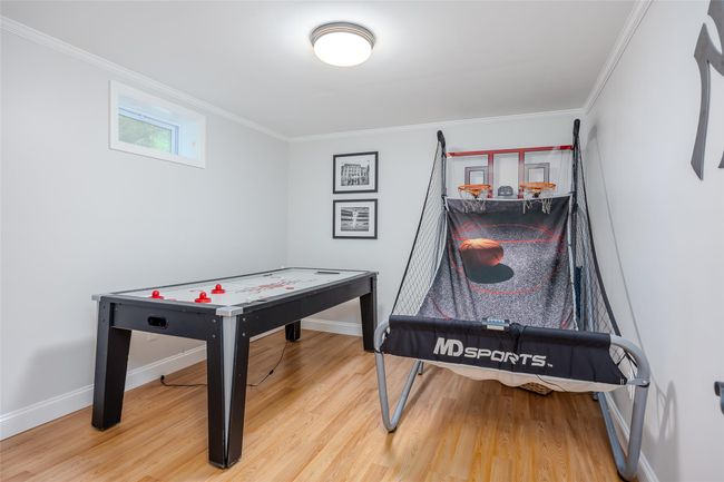 Recreation room with wood finished floors and crown molding | Image 34