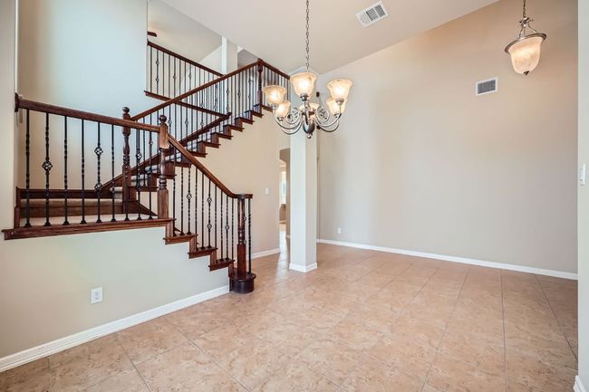 Stairs with a chandelier, tile patterned flooring, and a towering ceiling | Image 4