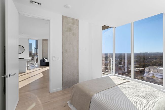 Bedroom featuring light wood finished floors, visible vents, and floor to ceiling windows | Image 11