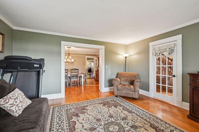 Another view of the living room overlooking the dining room with another door leading to the front foyer. | Image 36