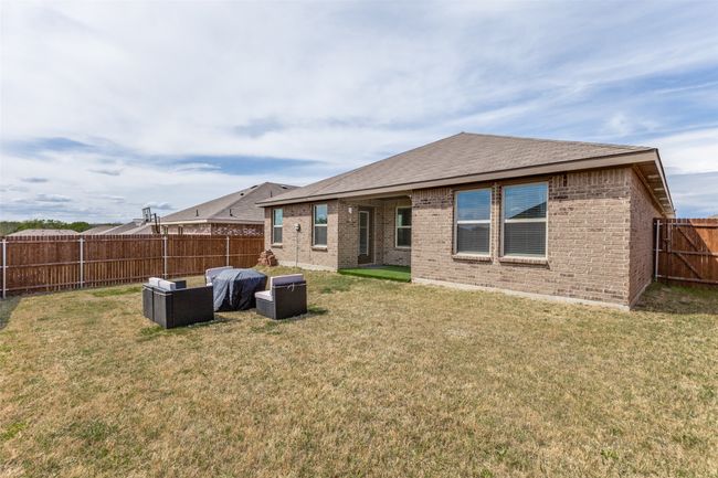 Back of house with a fenced backyard, brick siding, and a lawn | Image 24
