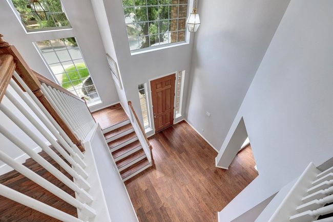 Entryway with a towering ceiling, stairs, dark wood-type flooring, and baseboards | Image 20