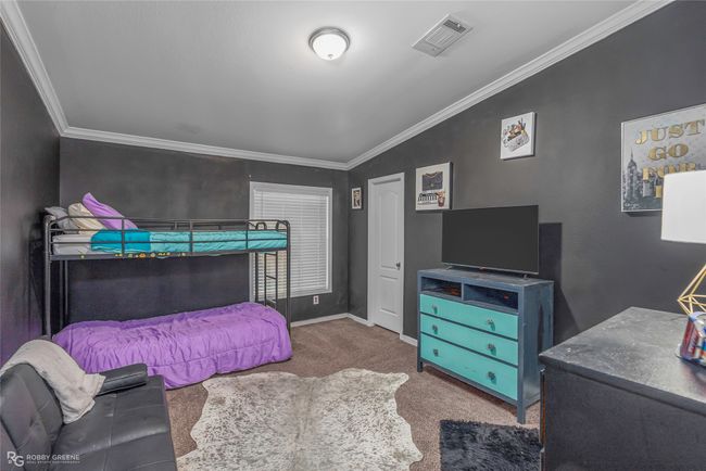 Bedroom featuring carpet flooring, crown molding, visible vents, and baseboards | Image 32