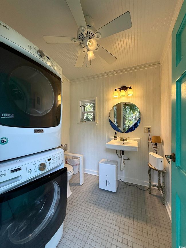 Laundry area with ornamental molding, ceiling fan, laundry area, stacked washer and dryer, and tile patterned floors | Image 34