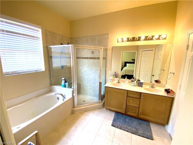 Full bath featuring a shower stall, connected bathroom, tile patterned floors, and a sink | Image 12