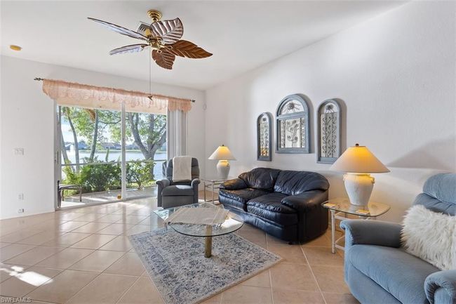 Living room with light tile flooring and ceiling fan | Image 7