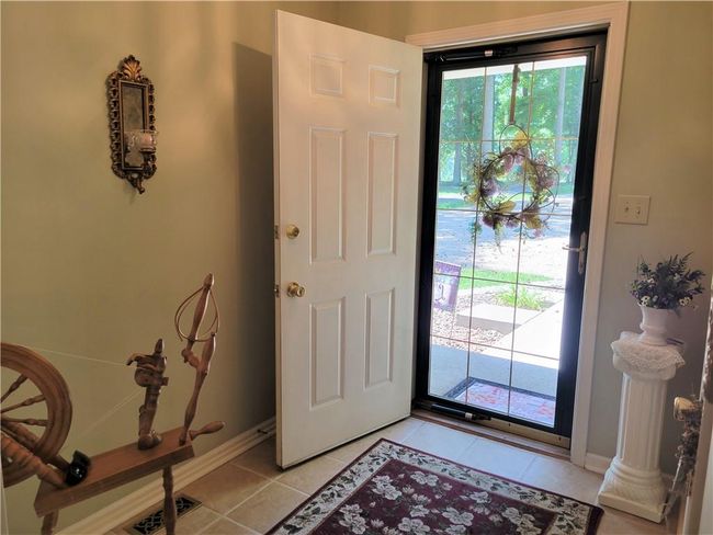 Entryway has tile flooring and a coat closet | Image 5