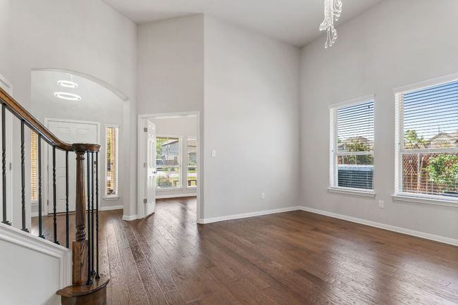 Entrance foyer with a high ceiling, an inviting chandelier, dark wood-style floors, and stairway | Image 8