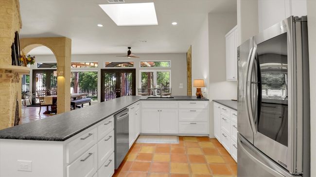 Kitchen with a peninsula, appliances with stainless steel finishes, a skylight, and plenty of natural light | Image 17