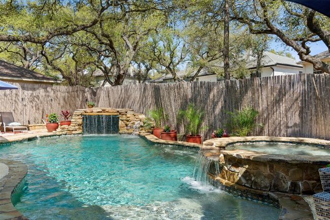 View of pool with a fenced backyard and a pool with connected hot tub | Image 37