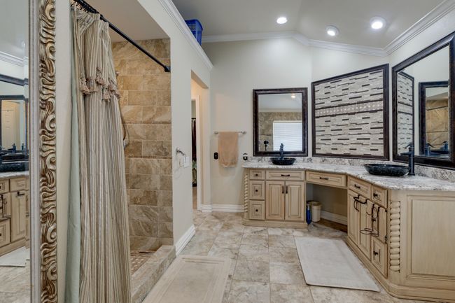 Bathroom featuring tiled shower, vanity, crown molding, and recessed lighting | Image 26