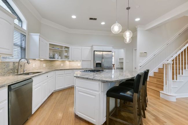 Kitchen featuring stainless steel appliances, large center island, and granite countertops. | Image 10